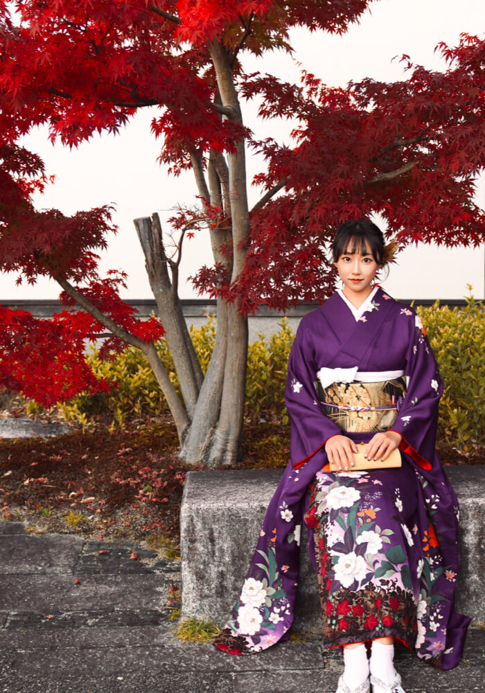 Geisha walking through lantern-lit street in Gion district at dusk