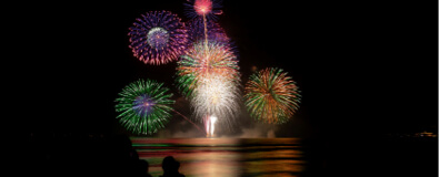 Crowd wearing yukata watching vibrant summer fireworks hanabi in Kyoto