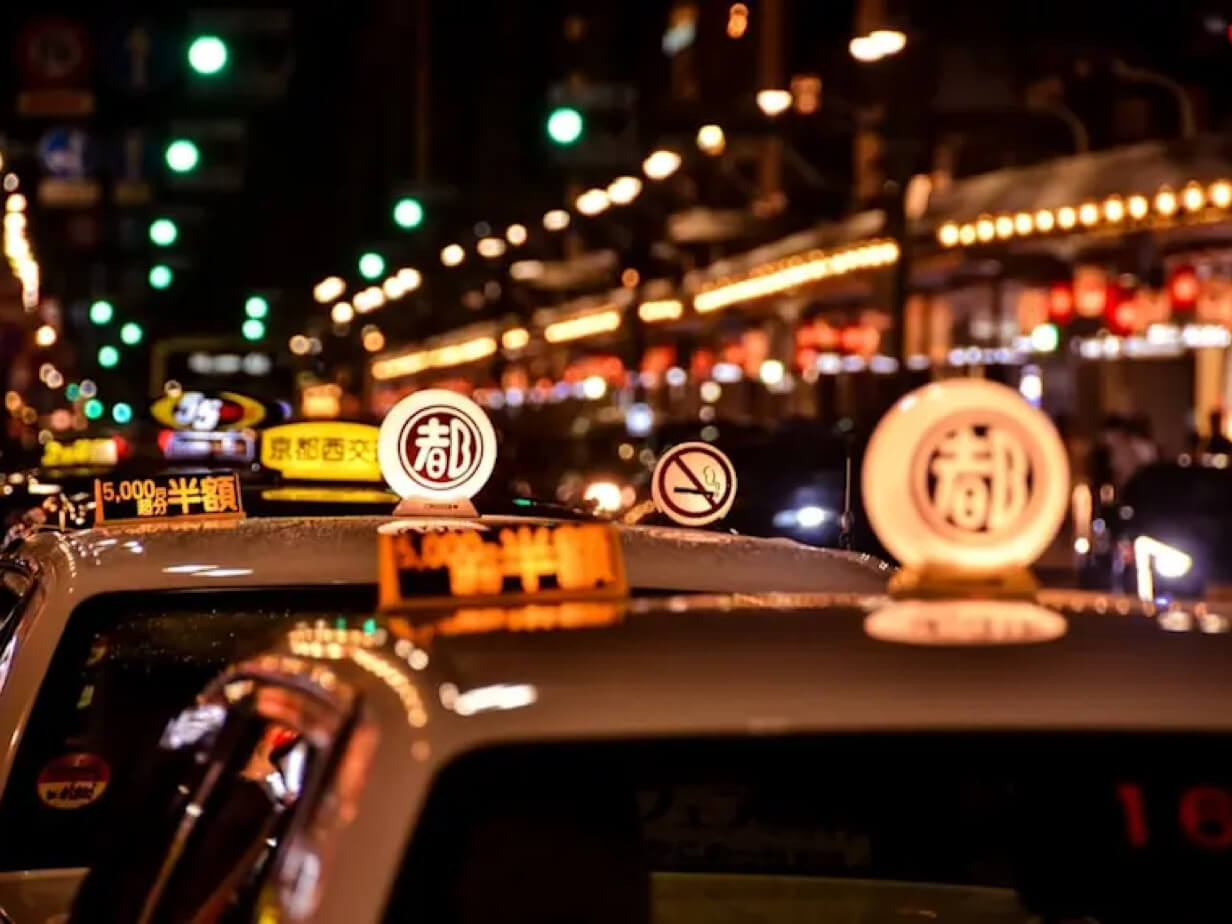 Elegant foreign woman wearing authentic silk kimono getting into a traditional Kyoto taxi